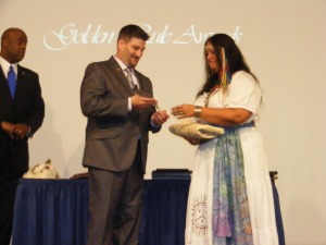 Dr. Williams is presented with a ceremony gift from the United Confederation of Taino People, Dr. Monika Ponton-Arrington.
